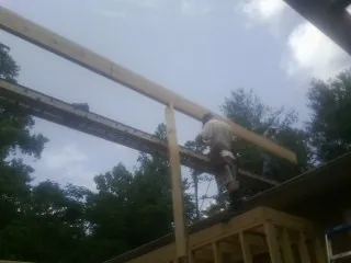 Carpenter setting a ridge beam over a new addition frame — Ice Dam Removal by Roofing Brothers in North Fort Myers